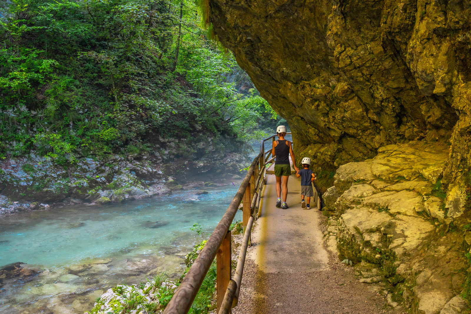 Tourists walking along the radovna river in vintgar gorge, near bled, slovenia, enjoying the stunning scenery and peaceful surroundings
