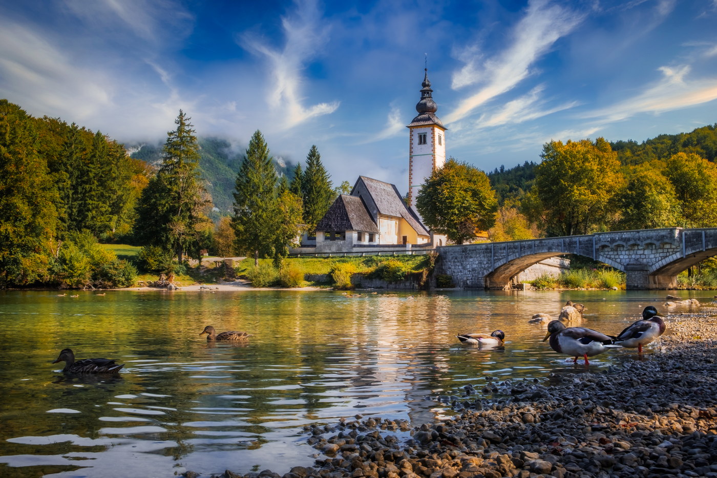 Scenic view of Lake Bohinj church with beautiful colorful foliage, Slovenia, Europe